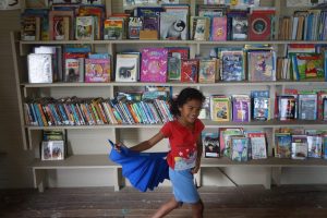 Drue Skipping through Library (supplied)